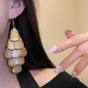 Detailed view of matte gold water drop tassel earrings with a vintage luxury aesthetic