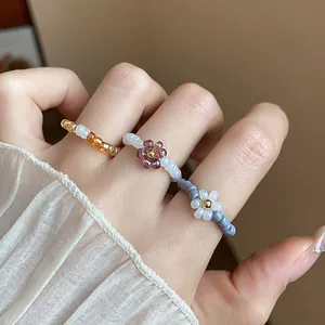 Close-up detail of colorful retro glass beaded flower elastic rings on model fingers