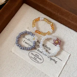 Macro shot of vintage handmade glass beaded rings featuring delicate flower accents.