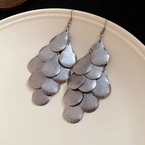 Detailed view of vintage matte metallic silver water-drop tiered tassel dangle earrings.
