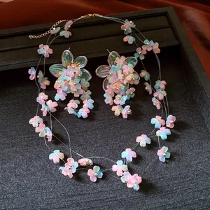 Detailed close-up of a colorful acrylic flower necklace and earring jewelry set on a black tray