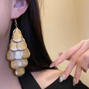 Close-up of gold tiered leaf drop earrings on model showcasing texture