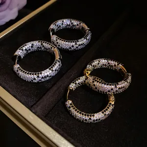 Eleganti orecchini a cerchio placcati oro 18 carati con zirconi pavé neri e bianchi.