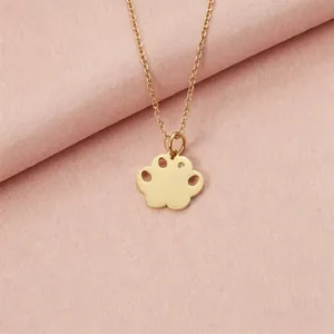Close-up of a gold stainless steel paw print pendant necklace with a small diamond accent.