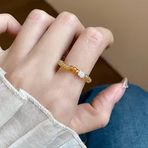 Detailed close-up showing a retro glass beaded elastic ring with amber and white beads