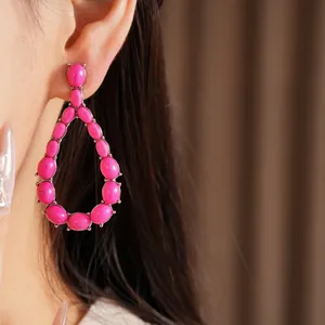 Primo piano di orecchini a goccia in pietra rosa con elegante castone in argento