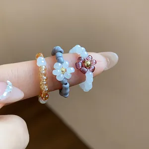 Close-up detail of handmade glass beaded elastic rings with delicate flower charms