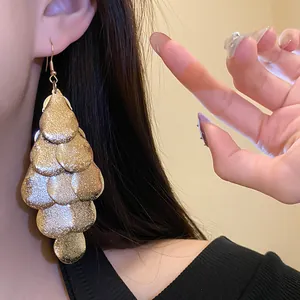 Close-up view showing the intricate texture of matte gold water drop layered tassel earrings.