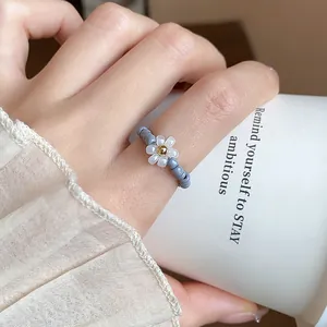 Close-up of vintage beaded flower elastic ring worn on a finger