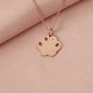 Close-up of a rose gold paw pendant necklace featuring a small sparkling crystal detail