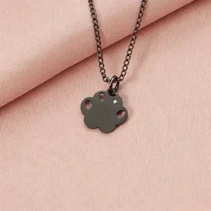 Macro view of a black stainless steel paw print necklace with a sparkling rhinestone detail.