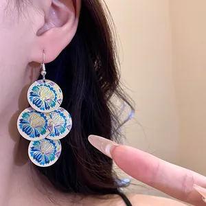 Detailed view of vintage floral enamel drop earrings featuring blue and gold patterns