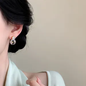 Primo piano di un elegante orecchino a lobo in zircone placcato oro 18k con motivo a pinguino