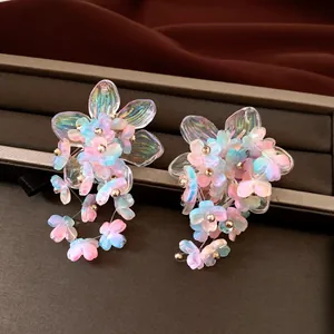 Detailed macro view of iridescent acrylic flower earrings with delicate bead accents
