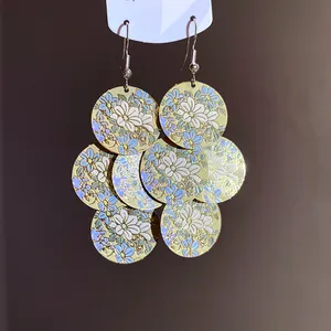 Detailed view of layered floral print circular discs on oversized drop earrings.