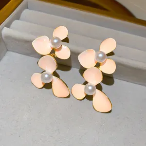 Macro detail of peach enamel flower petals with center pearls on elegant stud earrings