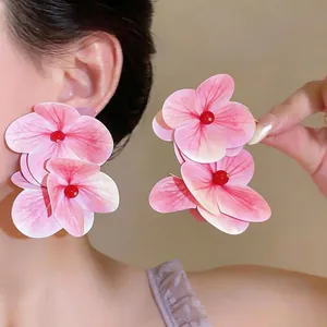Pendientes de flores rosas de gran tamaño para vacaciones en la playa y para fotos.
