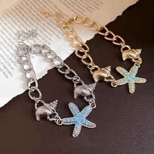 Elegant gold and silver chain bracelets featuring seashell and blue starfish charms