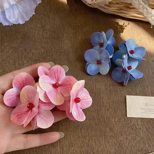 Pendientes de flores realistas de gran tamaño en rosa y azul para estilo de playa.