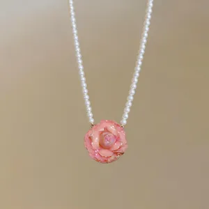 Elegant pearl necklace with a pink camellia flower pendant for a sweet aesthetic look.