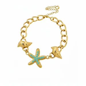 Gold starfish and seashell chain bracelet with turquoise accents on white backdrop.