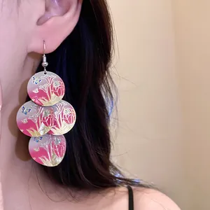 Close-up of elegant floral print drop earrings with artistic butterfly patterns