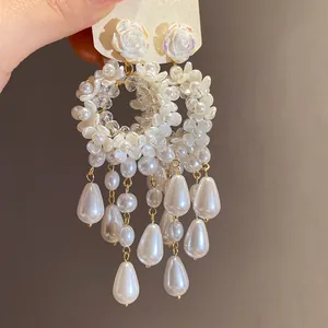 Close-up of French vintage earrings with resin flowers and teardrop pearls