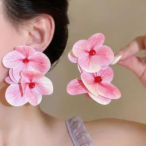 Vista detallada de pendientes de flores rosas extragrandes en el modelo