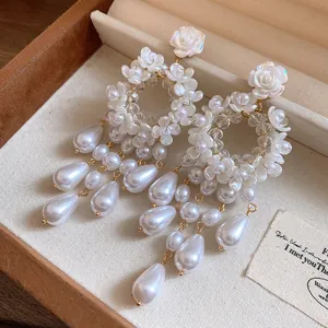 Detailed macro view of French vintage earrings featuring resin roses and pearl drops
