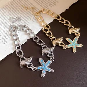 Detail view of gold and silver chain bracelets with seashell and starfish charms.