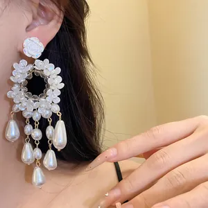 Detail shot of French retro flower drop earrings with white pearls and resin petals.