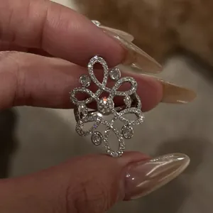 Detail of vintage hollow flower ring with pavé zircons held by fingers