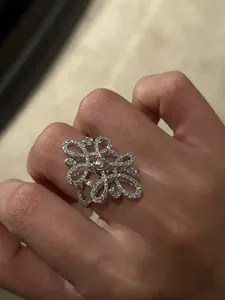Detailed close-up of a vintage openwork floral ring set with sparkling cubic zirconia.