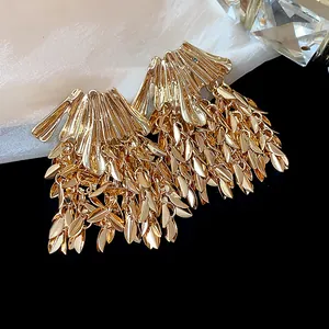 Detailed close-up view of elegant oversized gold wheat leaf tassel statement earrings