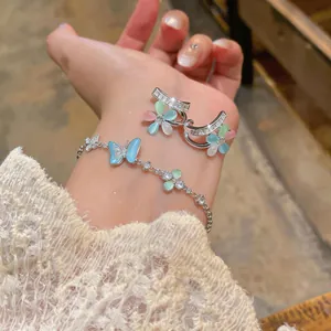 Detailed close-up of elegant silver floral earrings and butterfly bracelet on lace
