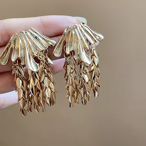 Close-up macro view of golden wheat ear leaf tassel statement earrings for women