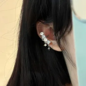 Detailaufnahme einer eleganten Ohrmanschette mit funkelnden Zirkonia und Stern