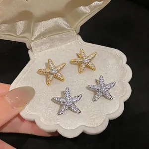 Elegant 18K gold-plated zircon starfish stud earrings presented in a white shell box