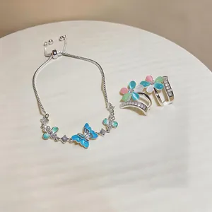 Detailed shot of silver butterfly bracelet and cat-eye stone flower jewelry jewelry set.