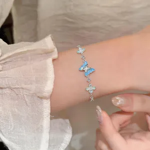 Elegant silver butterfly bracelet featuring blue enamel charms and cubic zirconia accents