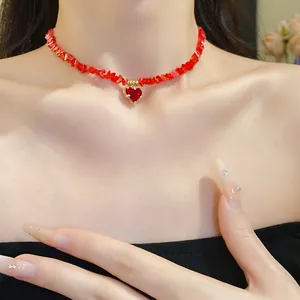 Detail shot of a stylish red crystal beaded heart necklace worn on a model's neck