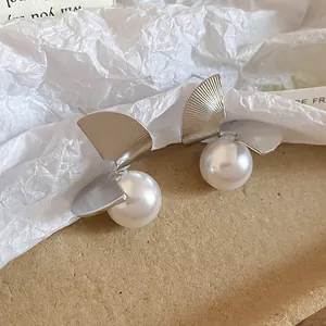 Close-up of French vintage silver fan-shaped pearl stud earrings with elegant texture