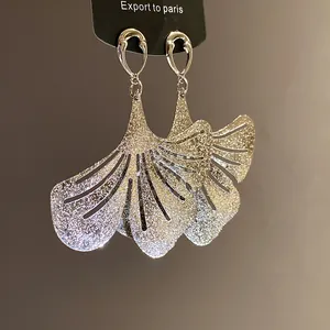 High-quality detailed macro shot of sparkling ginkgo leaf dangle earrings in silver finish