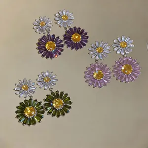 Detail view of colorful zircon daisy drop earrings in purple, pink and green.
