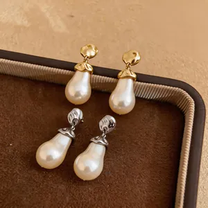 Detail view of elegant pear-shaped pearl earrings with gold and silver metallic accents