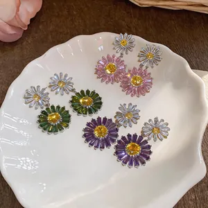 Close-up view of colorful daisy flower drop earrings with sparkling zirconia accents