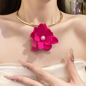 Close-up of fuchsia flower pendant choker with pearl center and golden metal ring
