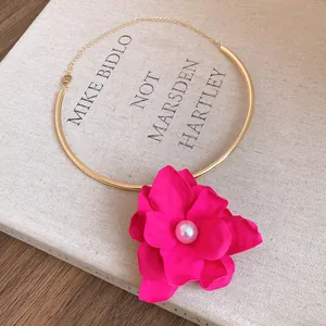 Close-up detail of vintage gold choker necklace featuring a large pink flower with pearl
