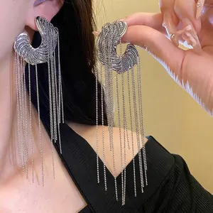 Elegant silver C-shaped earrings with long ball chain tassels for a modern and stylish look.