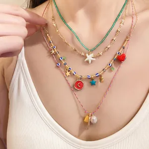 Close-up of a 4-piece layered necklace set with starfish, heart, and pearl charms.